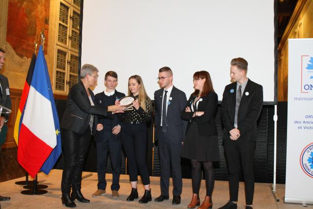 Geneviève Darrieussecq, secrétaire d'État auprès de la ministre des Armées, remet un prix aux jeunes lauréats du concours Bulles de mémoire