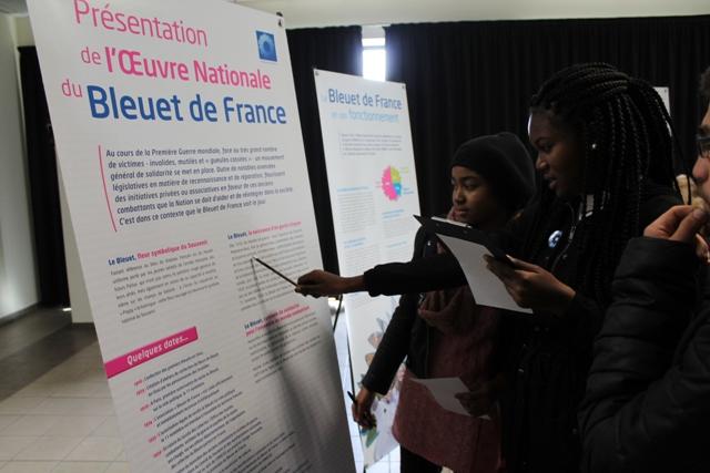Les jeunes devant l'exposition sur le Bleuet de France cherchant les réponses au quiz
