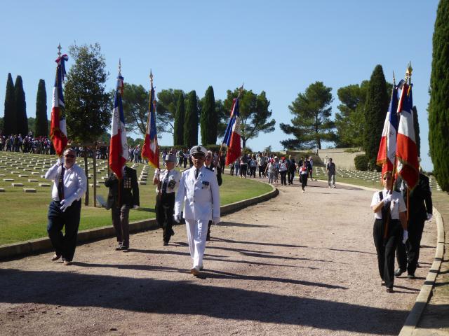 Les marcheurs quittant la nécropole, guidés par les porte-drapeaux à l'issue de la cérémonie